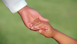 Bild av två händer som håller i varandra, ett barn och en vuxen
