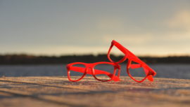 ett par röda glasögon som ligger på en brygga