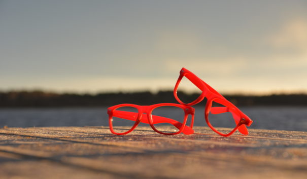 ett par röda glasögon som ligger på en brygga